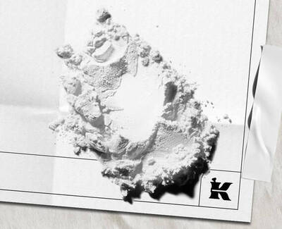 White powder ingredient scattered on white paper packaging with the Kiehl’s logo.