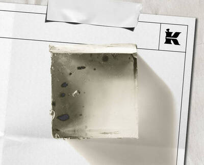 Transparent square soap bar with exfoliating specks, shown on white paper packaging with Kiehl’s logo.