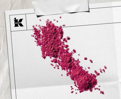 Bright pink powder pigment scattered across whitepaper packaging featuring the Kiehl’s logo.